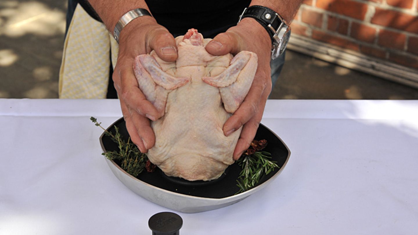 Das Huhn beherzt in beide Hände nehmen und fest auf den Sitzt drücken.