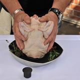 Das Huhn beherzt in beide Hände nehmen und fest auf den Sitzt drücken.