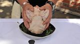 Das Huhn beherzt in beide Hände nehmen und fest auf den Sitzt drücken.