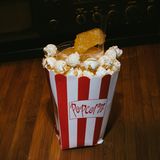 Cinema Cocktail  Im Kino hat es der Cocktail-Connaisseur oft schwer. Zeit, das zu ändern! Denn aus Mais kann man mehr machen als nur Popcorn - Bourbon zum Beispiel! In unserer Popcorntüte befindet sich daher nicht nur Popcorn, sondern auch ein versteckter Drink. Damit wird auch die schlechteste Fortsetzung auf der Leinwand erträglicher.  Zutaten:  55ml Bourbon Whiskey  40ml frisch gepresster Orangensaft  15ml Honig  1 Barlöffel Trüffelöl  10 Maiskörner  Trinkgefäß: Tumbler in einer Popcorntüte  Garnitur: Honigwabe  Zubereitung:  Trüffelöl mit den Maiskörnern in den Shaker geben und erhitzen (z. B. mit einem Zigarrenfeuerzeug), sodass die Maiskörner sich öffnen. Wenn alle Maiskörner sich geöffnet haben, die restlichen Zutaten in den Shaker geben, mit Eis füllen, schütteln und doppelt in das mit Eiswürfeln gefüllte Glas abseihen. Stellen Sie das Glas in die Popcorntüte, füllen Sie den Freiraum zwischen Glas und Popcorntüte mit Popcorn und garnieren Sie den Drink mit einer Honigwabe.