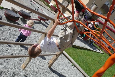 Kopfüber aus dem Klettergerüst baumeln? Das treibt übervorsichtige Eltern in den hysterischen Anfall, während die Manager-Mama das im Zweifel gar nicht mitbekommt.