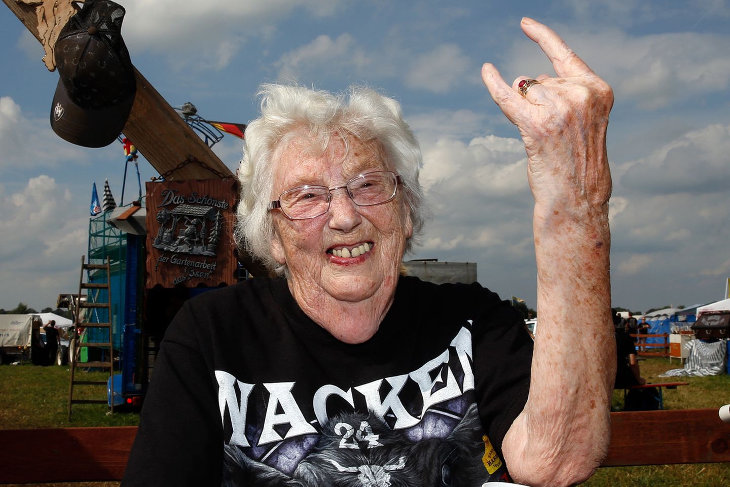25 Jahre Matsch und Metal: Das Wacken Open Air ist ein Treffen mehrerer Generationen, viele Familien fahren gemeinsam auf das Metal-Festival. Eine der ältesten Besucherinnen des vergangenen Jahres dürfte auf jeden Fall diese 90-jährige Frau sein, die gekonnt die "mano cornuta", die Teufelshörner, in die Luft reckt. Metaller nennen die Geste auch liebevoll Pommesgabel. Das Wacken Open Air ist ein Treffen mehrerer Generationen, viele Familien fahren gemeinsam auf das Metal-Festival. Eine der ältesten Besucherinnen des vergangenen Jahres dürfte auf jeden Fall diese 90-jährige Frau sein, die gekonnt die "mano cornuta", die Teufelshörner, in die Luft reckt. Metaller nennen die Geste auch liebevoll Pommesgabel.