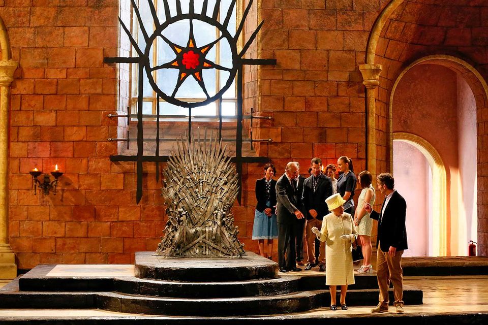 Windsor is coming: Königin Elisabeth II. besuchte bei ihrem Staatsbesuch 2014 in Belfast die Dreharbeiten zur fünften Staffel der HBO-Serie "Game of Thrones". Mit dabei: ihr Ehemann Prinz Philip. Während Philip mit den Darstellern plauderte, diskutierte die englische Königin mit einem Mitarbeiter. "Game of Thrones" gehört aktuell zu den erfolgreichsten Serien der Welt. Es handelt sich dabei um eine Verfilmung der Fantasy-Saga "Das Lied von Eis und Feuer" des amerikanischen Autors George R. R. Martin.