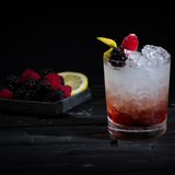 Bramble  Der Bramble ist eine kleine, aber feine Variation des Gin Sour. Durch die Zugabe des Brombeerlikörs Crème de Mûre entwickelt der Drink eine voluminöse Fruchtigkeit, die durch den Gin trocken unterfüttert wird. Kreiert wurde er in den 1980er-Jahren vom Londoner Bartender Dick Bradsell und war damit einer der ersten Drinks, die den süßen Mischungen dieser Zeit wieder etwas klassische Eleganz entgegensetzten.  Zutaten:  40ml Gin  20ml Crème de Mûre  20ml frisch gepresster Zitronensaft  15ml Läuterzucker  Trinkgefäß: Tumbler  Garnitur: Zitronenspalte, Brombeeren  Zubereitung:  Alle Zutaten außer Crème de Mûre in den Shaker geben und mit Eiswürfeln kräftig schütteln. Mit dem Barsieb in einen Tumbler auf Crushed Ice abseihen und die Crème de Mûre vorsichtig über den Drink geben.