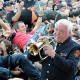 Trompete statt Gitarrenriffs: Die Wacken Firefighters, die Blaskapelle der örtlichen Feuerwehr, spielen zum Festival-Auftakt im Biergarten Volkslieder und Adaptionen bekannter Songs. Im Hintergrund verwandelt sich die tobsüchtige Meute in ein betrunkenes, schunkelndes Menschenmeer.