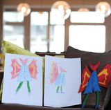 John ist schon 15 und hat seiner Mutter nicht geglaubt, dass er ihr ein Bild fürs Büro malen sollte. "Dein Ernst??" Das Geheimnis flog auf, aber der Teenager fand die Idee trotzdem super. Und malte seinen "Mr. Coat" gleich in Frontal- und Seitenansicht, damit die Näherinnen auch genau wüssten, wie er aussehen soll. Als er seine Puppe in der Hand hielt, sagte er: "Guck mal, die haben sogar die Schnürsenkel auf die Schuhe gestickt!"