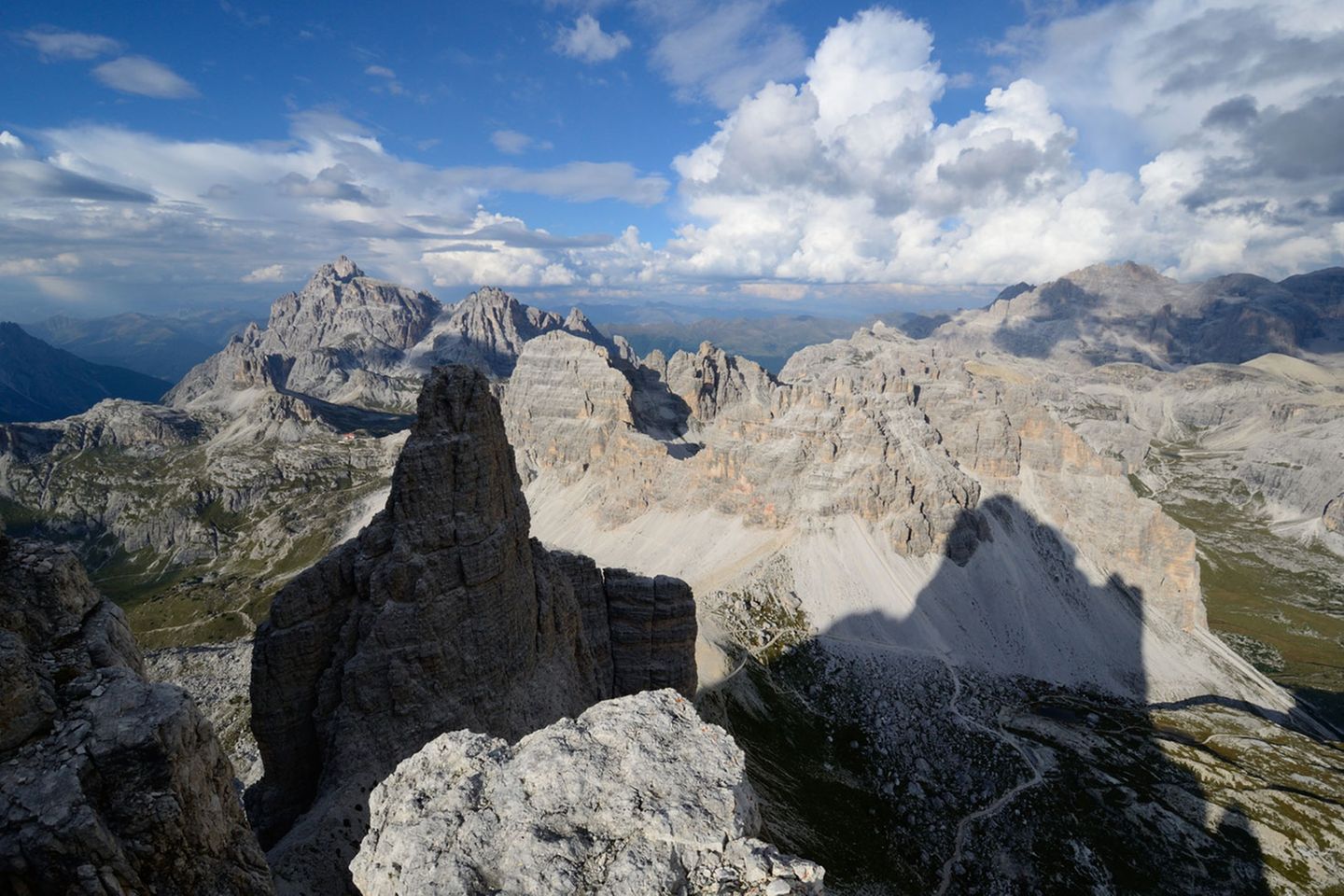 Drei Zinnen: Kleine Zinne: Südkante Blick vom Vorgipfel der Kleinen Zinne auf das nordöstliche Ende der Dolomiten mit Dreischusterspitze und Paternkofel. Dazwischen schmiegt sich auf dem Pass die Drei-Zinnen-Hütte. Rechts im Schatten verläuft der Fußweg vom Parkplatz an der Auronzo-Hütte über den Paternsattel zur Drei-Zinnen-Hütte. In den Sommermonaten laufen über diese "Drei-Zinnen-Autobahn" die Touristenmassen, um einen Blick auf die berühmten Nordwände zu erhaschen. Kleine Zinne: Südkante Blick vom Vorgipfel der Kleinen Zinne auf das nordöstliche Ende der Dolomiten mit Dreischusterspitze und Paternkofel. Dazwischen schmiegt sich auf dem Pass die Drei-Zinnen-Hütte. Rechts im Schatten verläuft der Fußweg vom Parkplatz an der Auronzo-Hütte über den Paternsattel zur Drei-Zinnen-Hütte. In den Sommermonaten laufen über diese "Drei-Zinnen-Autobahn" die Touristenmassen, um einen Blick auf die berühmten Nordwände zu erhaschen.
