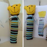 Judith hat zur Geburt einen kleinen Teddy geschenkt bekommen, "Margot" ist seither ihr allerwichtigstes Kuscheltier. Da sie neun Jahre alt ist, hat sie seinen Körper inzwischen komplett weggeliebt, er musste durch eine mit Watte gefüllte Socke ersetzt werden. Als Judith ihr Lieblingskuscheltier malen sollte, hat sie keine Sekunde gezögert. Die Näherinnen in Bali kannten die Vorgeschichte natürlich nicht und haben sich strikt an Judiths Zeichnung gehalten. "Die haben sogar die Blümchen und Kleeblätter auf dem Taschentuch, mit dem Margot an der Socke befestigt ist, gestickt! Dass sie die auf meinem Bild überhaupt erkannt haben!", schwärmt Judith begeistert. Die Gefährtin für Margot heißt Tante Marla.