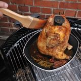 Nach 40 Minuten bei rund 200 Grad ist es soweit: Kross und prall thront das "Bierhintern-Huhn" auf seinem Sitz. Noch einmal mit Marinade einpinseln. Wieder den Deckel drauf, die Lüftung im Deckel schließen und weitere zehn Minuten garen.