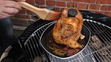 Nach 40 Minuten bei rund 200 Grad ist es soweit: Kross und prall thront das "Bierhintern-Huhn" auf seinem Sitz. Noch einmal mit Marinade einpinseln. Wieder den Deckel drauf, die Lüftung im Deckel schließen und weitere zehn Minuten garen.