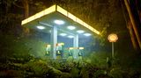 Von David LaChapelle inszeniert und illuminiert sieht diese Shell-Tankstelle aus, als läge sie mitten im Urwald. Sie wirkt wie eine Kulisse in einem David-Lynch-Film