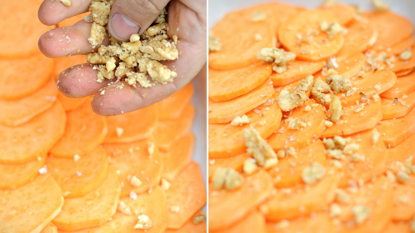 Schritt 3: Jetzt belegen wir die erste Schicht. Eine Handvoll Walnüsse und Cashews zerkleinern, Klaus Breinig macht das mit bloßen Händen. Die Splitter dann über die erste Schicht verteilen.