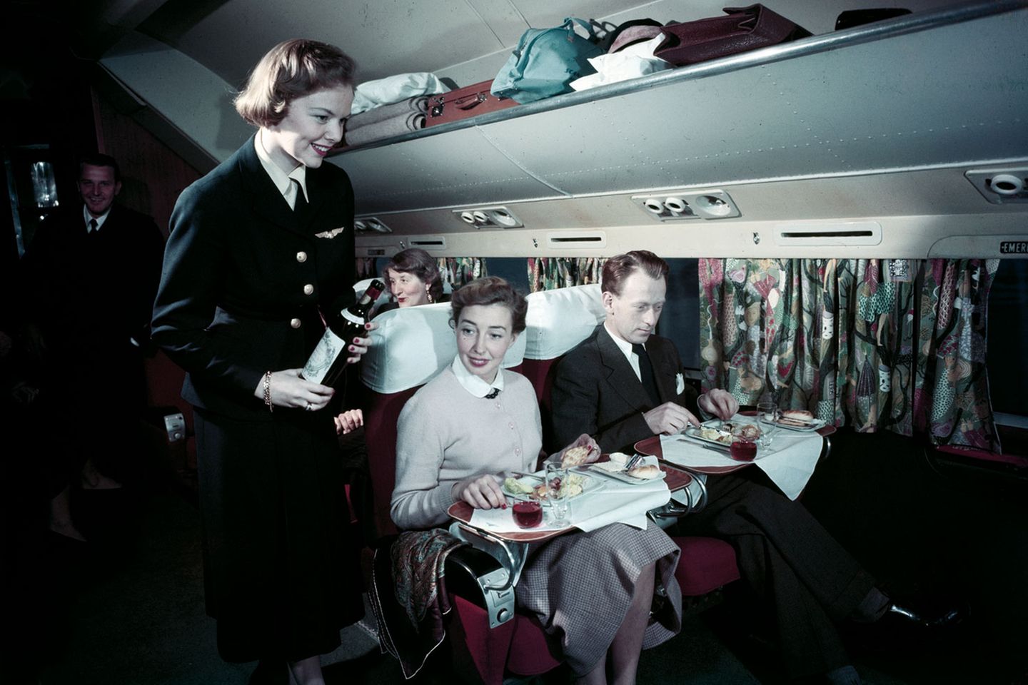 Offene Gepäckfächer wie bei der Bahn, Gardinen vor den Fenstern und ein reich gedeckter Tisch: in der First Class einer Douglas DC-6B von SAS.