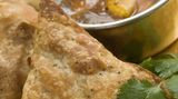 Samosas sind die pikant gefüllten Teigtaschen aus dem Norden Indiens. Gewürzt wird mit Kreuzkümmel und Safran. In Indien werden die Samosas oft mit Essensresten gefüllt: Gemüsecurrys mit Reis und Kartoffeln, aber auch mit Fleisch und Fisch. Der Teig besteht aus Wasser und Mehl. Sie werden zu Dreiecken geformt und im heißen Fett frittiert. Dazu wird oft ein Chutney gereicht.