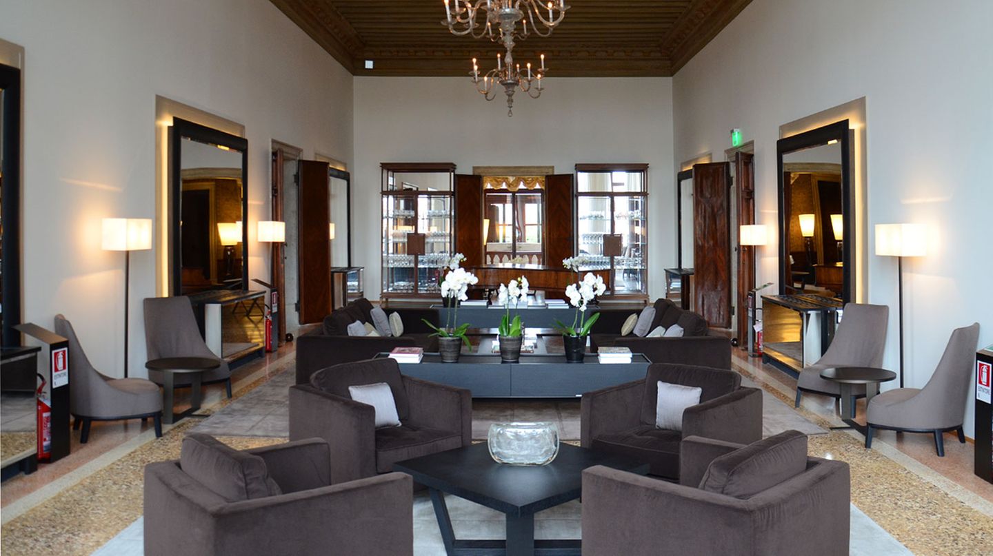 Eher schlicht wirkt der Salon aus einer anderen Perspektive mit modernen Murano-Leuchtern unter der hohen Holzdecke.