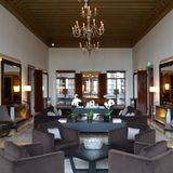 Eher schlicht wirkt der Salon aus einer anderen Perspektive mit modernen Murano-Leuchtern unter der hohen Holzdecke.