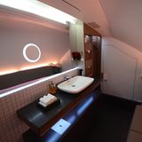Im Oberdeck übersteigen die Ausmaße der Toiletten der First Class die Größe vieler Badezimmer von Drei-Zimmer-Wohnungen. Statt auf glitzernde Opulenz und Duschen wie bei Emirates in der ersten Klasse setzt Qatar auf die klare Optik eines Designer-Hotels.