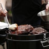 So sieht unser Pulled Pork nach etwa zehn Stunden im Bulletsmoker aus. Das Stück hat deutlich an Gewicht verloren. Zeit zum Moppen! Der Name kommt vom kleinen Wischmopp, mit dem eine würzige Soße, dem "Mopp" großzügig aufgebracht wird. Es darf dabei gern zügig zugehen, jedes Deckelöffnen senkt die Temperatur, unterbricht die Zirkulation der heißen Luft und verlängert so die Garzeit.