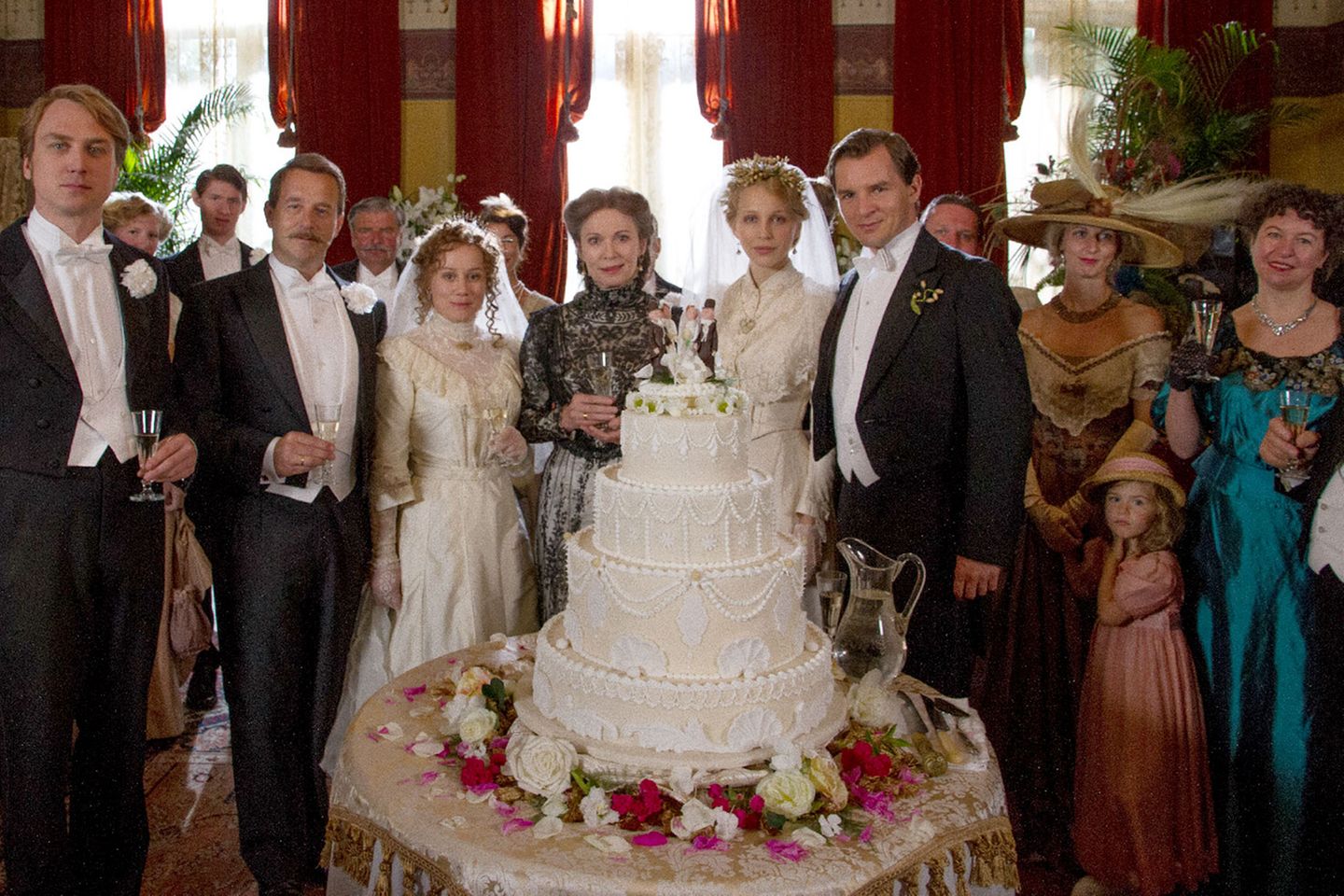 "Der Wagner-Clan": Anfangs gelingt es Cosima, die Familie zusammenzuhalten. Beide Töchter heiraten. Der Film nimmt sich - nicht nur in dieser Szene - großzügige Freiheiten heraus und macht aus den Eheschließungen der beiden Töchter Eva (Eva Löbau, 3.v.l.) und Isolde (Petra Schmidt-Schaller, 5.v.l.) eine Doppelhochzeit. In Wahrheit lagen acht Jahre dazwischen. Isolde heiratete bereits 1900 den Schweizer Dirigenten Franz Beidler. Anfangs gelingt es Cosima, die Familie zusammenzuhalten. Beide Töchter heiraten. Der Film nimmt sich - nicht nur in dieser Szene - großzügige Freiheiten heraus und macht aus den Eheschließungen der beiden Töchter Eva (Eva Löbau, 3.v.l.) und Isolde (Petra Schmidt-Schaller, 5.v.l.) eine Doppelhochzeit. In Wahrheit lagen acht Jahre dazwischen. Isolde heiratete bereits 1900 den Schweizer Dirigenten Franz Beidler.