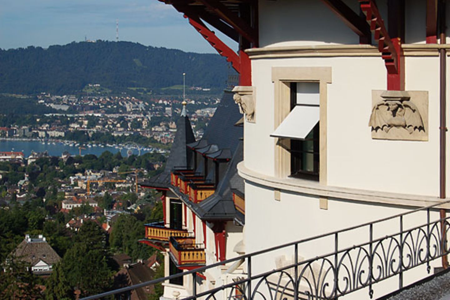 Belle Epoche über den Dächern von Zürich: Zipfelmützenzwerge und beflügelte Dämonen tragen an der alten Schlossfassade Teile der hölzernen Dachkonstruktion