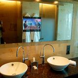 Badezimmerwände aus poliertem Jura-Kalk und beheizte Böden: In die Spiegelflächen sind TV-Flachbildschirme integriert, um bei Rasur oder Make-up nicht auf die Nachrichten verzichten zu müssen