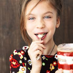 Mädchen mit einem Glas Müsli in der Hand