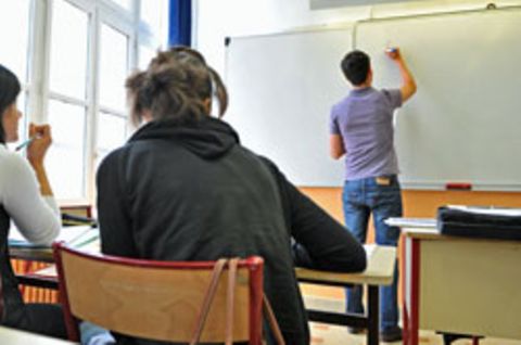Ein junger Lehrer beschriftet die Tafel. Nachwuchslehrer sind knapp, die Bundesländer werben sich die Kräfte gegenseitig ab