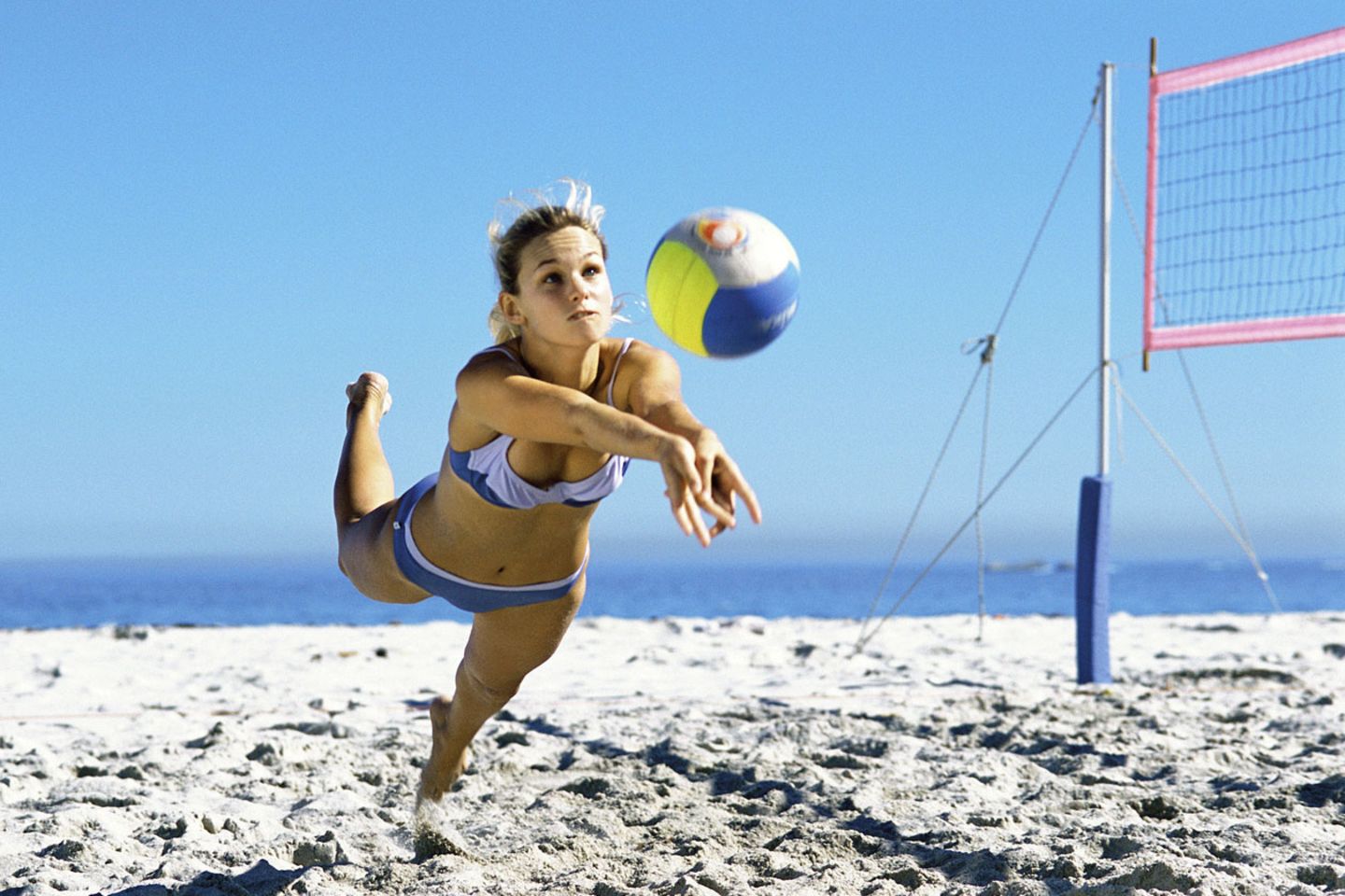 Eine Frau, die Volleyball spielt und zum Ball rennt: Beim Sport verbraucht der Körper viele Kalorien