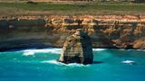 Vom Helikopter aus bietet sich ein grandioser Blick auf einsame Felsriesen vor der buntgestreiften Steilküste im Süden Australiens