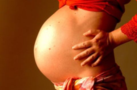 Eine schwangere Frau streckt ihren Babybauch raus. Als eine Britin bereits in anderen Umständen war, wurde sie innerhalb weniger Wochen ein weiteres Mal schwanger