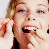 Mit Zahnseide und Zwischenraumbürsten lassen sich die Beläge zwischen den Zähnen entfernen