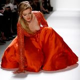 Viele Designerkleider sind passgenau geschneidert und ausschließlich für das Tragen in aufrechter Steh- und Gangposition gedacht. Wie sich der Blick auf das Dekolletee ändert, wenn diese Bedingungen nicht gegeben sind, demonstriert dieses Model in einem Traum aus Orange während der Dennis-Basso-Show auf der New York Fashion Week im Februar 2012.