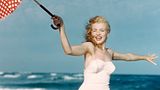 Marilyn Monroe turnt im Badeanzug über den Strand, Anfang der 50er Jahre. Der Zeit angemessen, doch für ihre Verhältnisse ist sie ziemlich bekleidet.