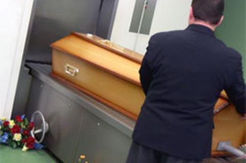Ein Sarg in einem Krematorium wird in die Verbrennungsanlage geschoben. Die Angeklagten sollen sich in 600 Fällen bereichert haben