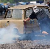 Ein qualmende "Rennpappe" quält sich durch den Schlamm im Fahrerlager