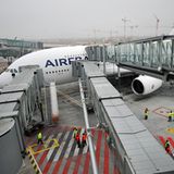 Applaus bei der Landung  Die Flughafenfeuerwehr begrüßt den Neuankömmling mit Fontänen im Regen, das Bodenpersonal steht Spalier. Durch die drei parallelen Fluggaststeige verläuft das Aussteigen zügig. Flughäfen, auf denen der neue Superjumbo landet, müssen entsprechend umgerüstet und "A380-fähig" sein, um auf zwei Ebenen die Passagiere abfertigen zu können