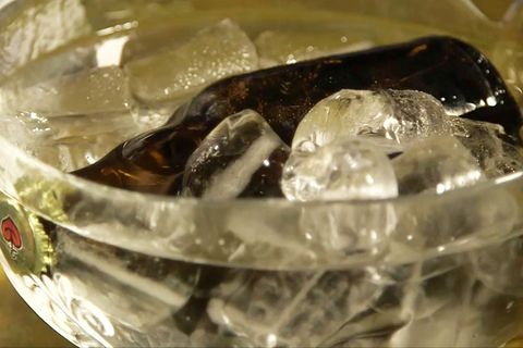 Eine Flasche Bier liegt in einer Schüssel mit Eiswürfeln.
