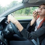 Kleine Schminkarbeiten am Steuer werden in Deutschland toleriert. In Großbritannien kann es dafür aber ein saftiges Bußgeld geben.