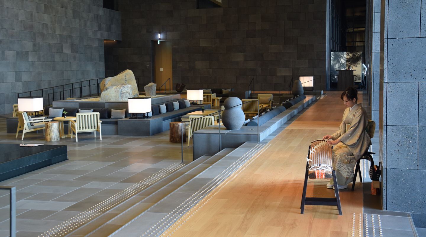 In der Lobby des Aman Tokio zupft eine Musikerin die 13 Saiten der Koto, der japanischen Zither.