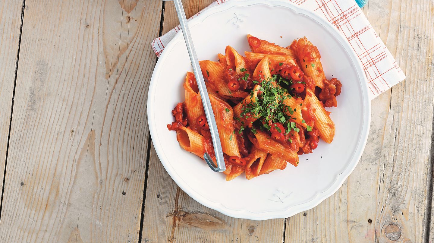 Ein Teller mit dampfender Pasta all'arrabbiata - die scharfen Nudeln