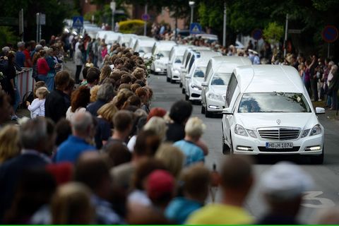 Ein Konvoi aus mehreren Leichenwagen fährt in Haltern an einer Menschenmenge vorbei