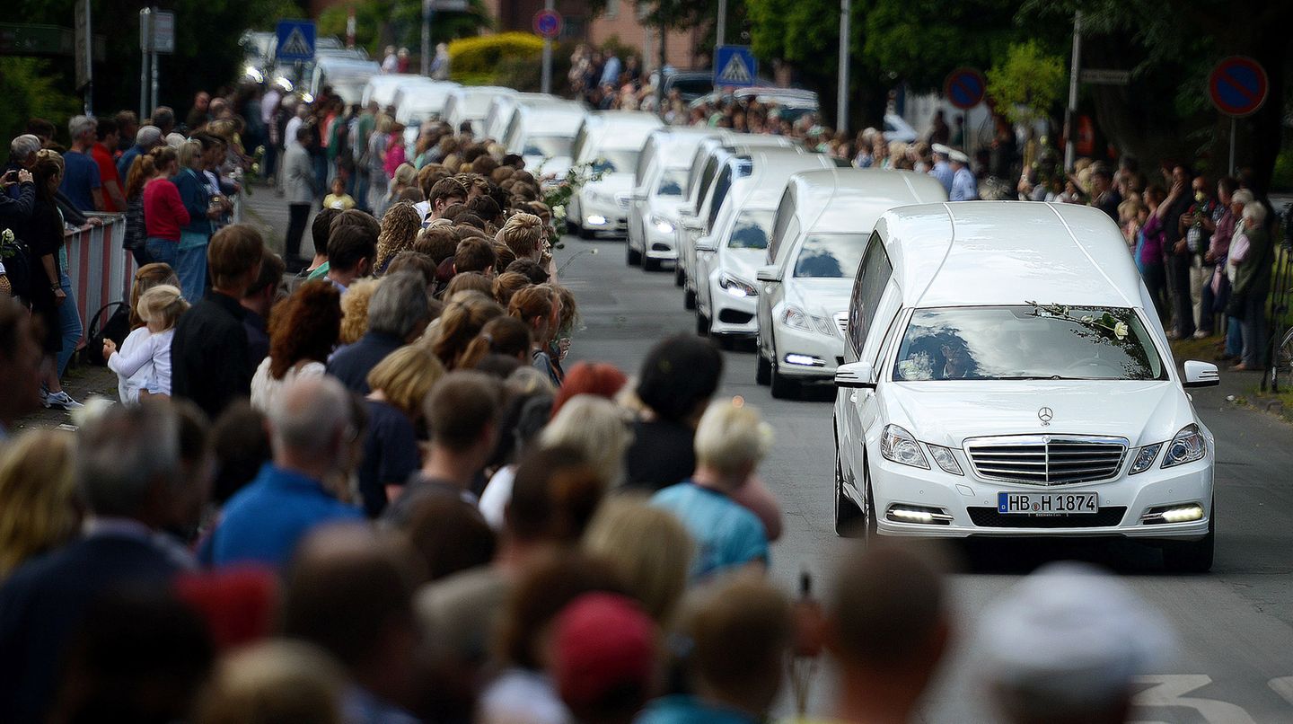Ein Konvoi aus mehreren Leichenwagen fährt in Haltern an einer Menschenmenge vorbei