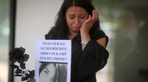 Eine Frau trauert bei einer Mahnwache vor dem Gerichtsgebäude in Darmstadt um Tugce