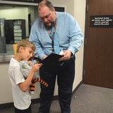 James Parker erzählt dem Sechsjährigen von den Abenteuern, die Hobbes erlebt hat und zeigt ihm die Fotos