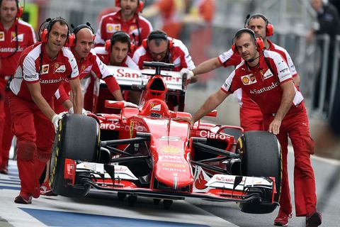 Mit vereinten Kräften schieben die Ferrari-Mechaniker Vettels Boliden zurück in die Box