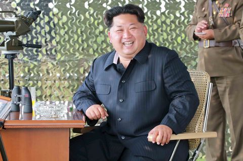 Kim Jong Un sitzt grinsend