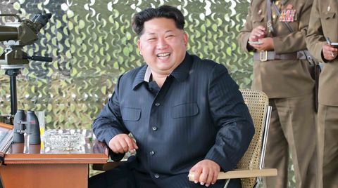 Kim Jong Un sitzt grinsend