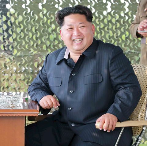 Kim Jong Un sitzt grinsend