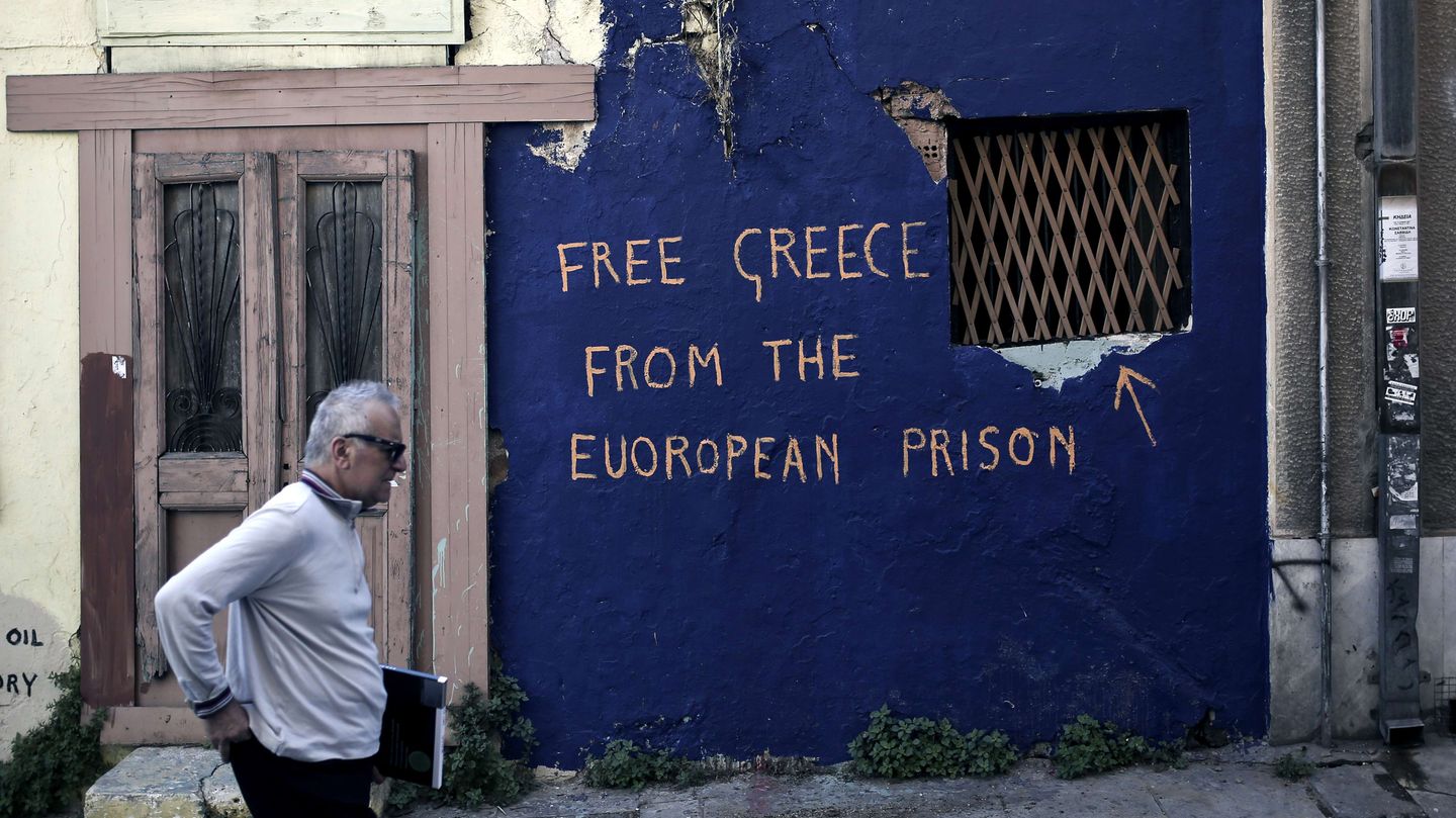 Ein Mann passiert in Athen ein Graffiti, das besagt: "Free greece from the european prison"