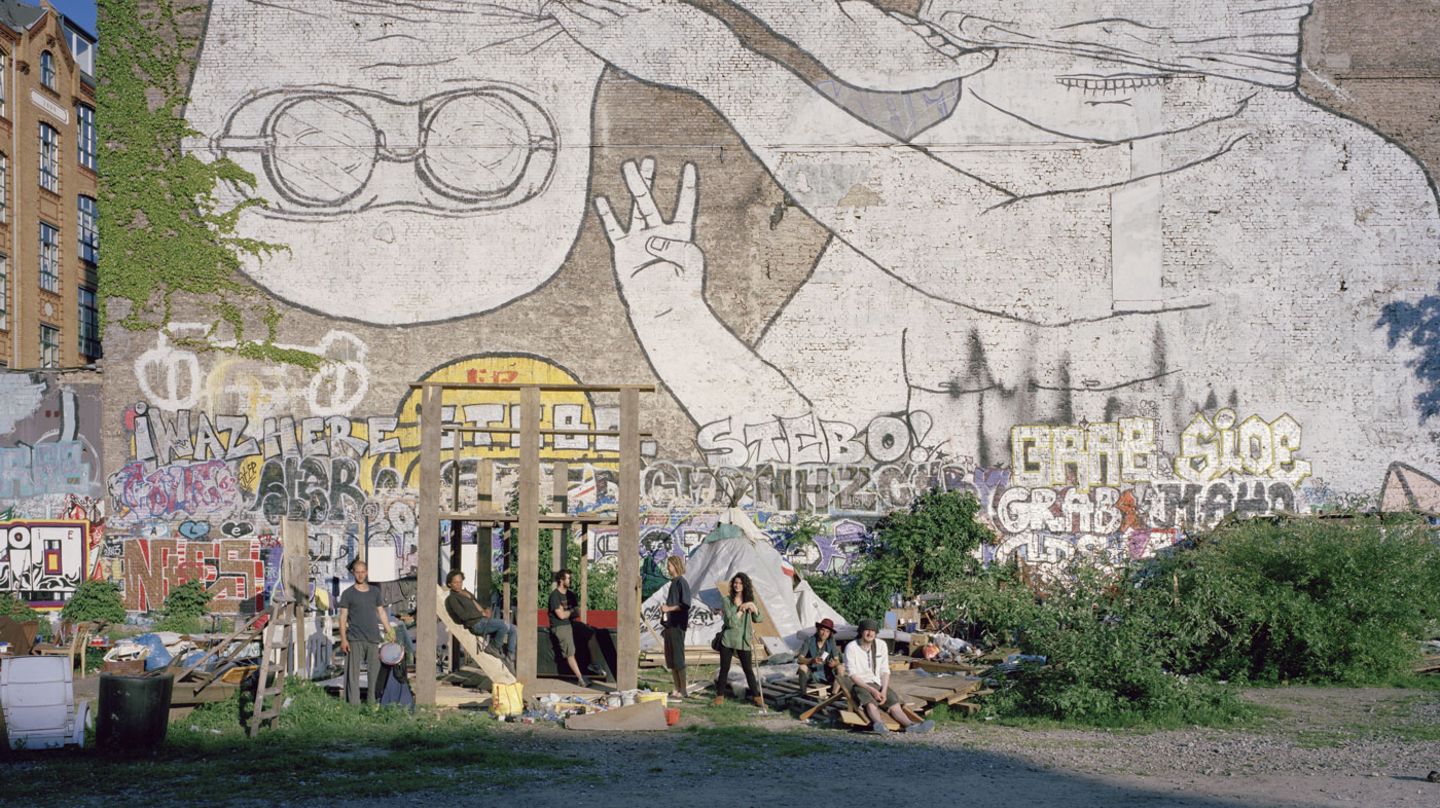 Andreas, Mama und ihre Freunde vor dem Wahrzeichen der Cuvry, dem Graffito von BLU und JR.